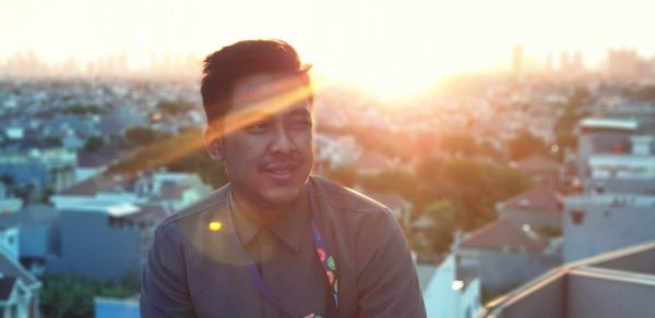 Man looking away in city during sunset