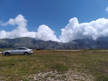 Cars on field against sky