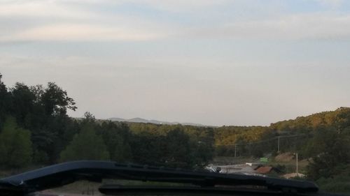 Scenic view of trees and mountains against sky