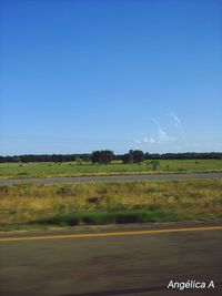 Scenic view of field against clear blue sky