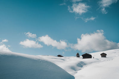 Snow covered landscape against blue sky