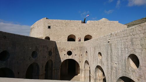 Low angle view of historical building against blue sky