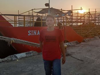 Full length portrait of man standing against sky during sunset