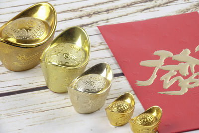 High angle view of ingot feng shui and red card on table