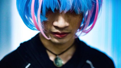 Close-up of young man wearing wig