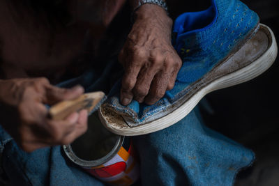 Close-up of person holding old shoe