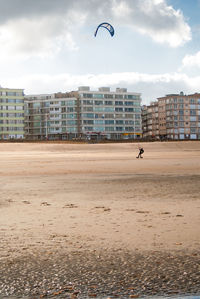 Kitesurfer riding on a sandy beach at the belgium coast at autumn