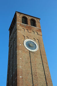 Low angle view of bell tower against blue sky