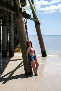 Woman standing against pier at beach