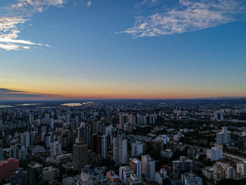 High angle view of modern buildings in city against sky during sunset