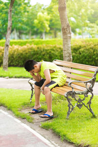 Side view of woman sitting on park