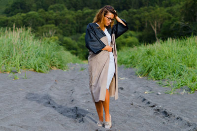 Full length of mid adult woman standing on sand