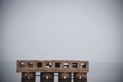 Old building by sea against clear sky