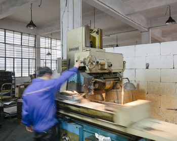 Rear view of man working in factory