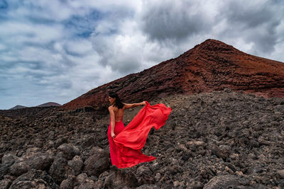 Rear view of woman on mountain against sky