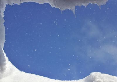 Close-up of snow against blue sky