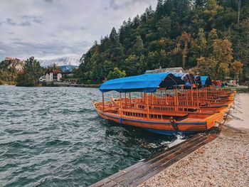 View of boat in lake bled against autumn sky.
