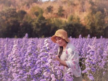 Full length of woman with pink flowers on field