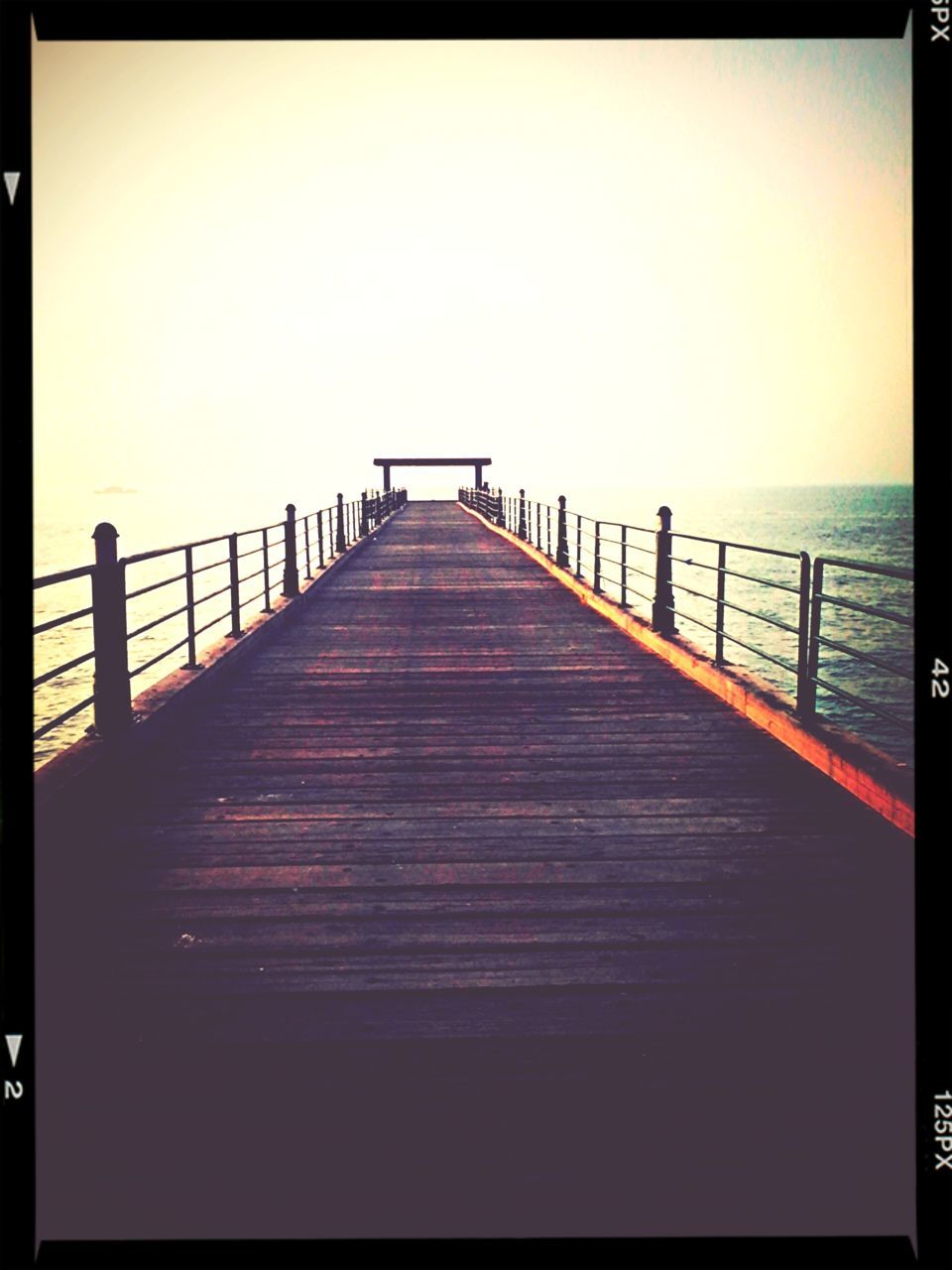 transfer print, sea, water, auto post production filter, pier, horizon over water, tranquil scene, tranquility, the way forward, railing, scenics, clear sky, sky, nature, beauty in nature, diminishing perspective, copy space, wood - material, jetty, long