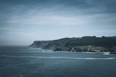 Scenic view of rocky coast and sea against sky