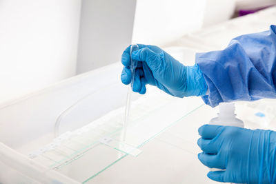 Cropped hand of scientist examining chemical in bathroom