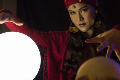 Portrait of female fortune teller with sphere at home