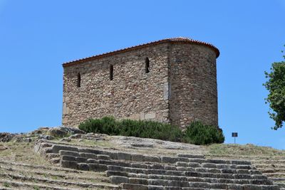 Low angle view of old building against clear blue sky