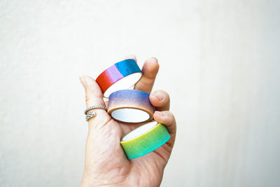 Cropped hand of person holding pills against white background