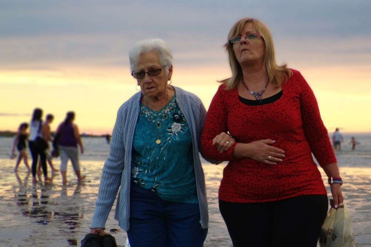 lifestyles, togetherness, leisure activity, bonding, love, casual clothing, beach, person, standing, water, happiness, vacations, sea, looking at camera, friendship, portrait, sunset, smiling