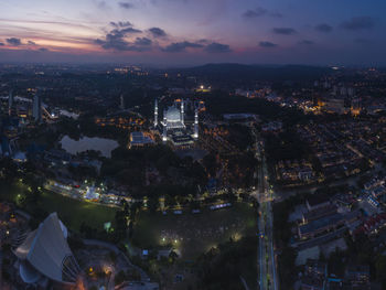 High angle view of illuminated city against sky at sunset