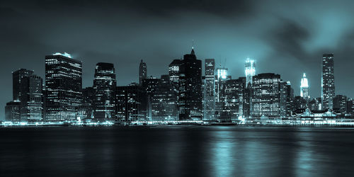 Illuminated buildings in city against sky at night