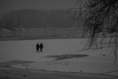 People walking on snow covered landscape