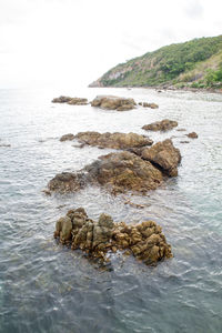 Rocks in sea against sky