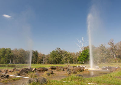 View of waterfall on field against sky