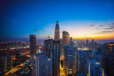 Illuminated cityscape against sky at night