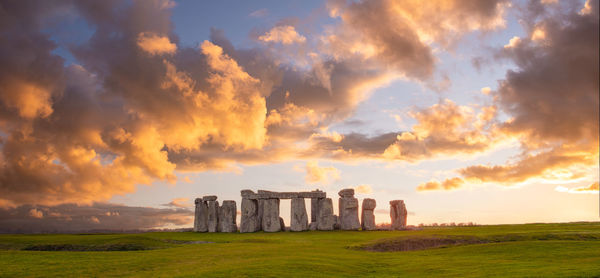 Amazing sunset at stonehenge in england with dramatic sky and sun rays