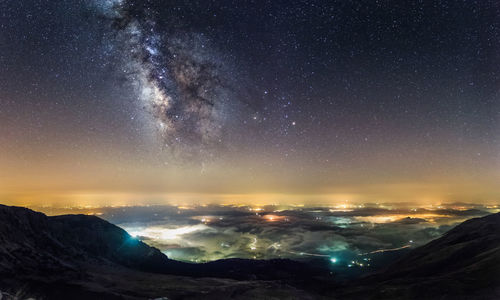 Scenic view of mountains against sky at night