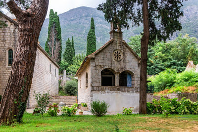 Old stone church with red tiled roof at near mountains, near risana, boca-kotor bay, montenegro