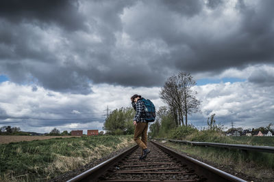 Man standing on railroad track against sky