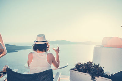 Rear view of woman looking at sea against clear sky