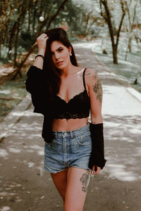 Beautiful young woman standing against tree