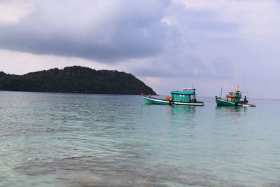 Boat moored in sea against sky