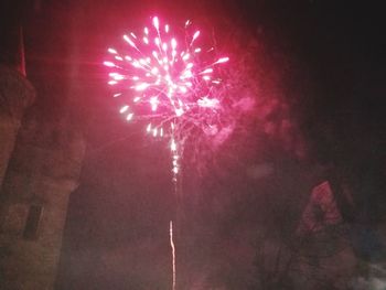 Low angle view of firework display at night