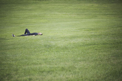 Mid distance view of man lying down over grassy land