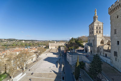 Buildings in city against clear blue sky