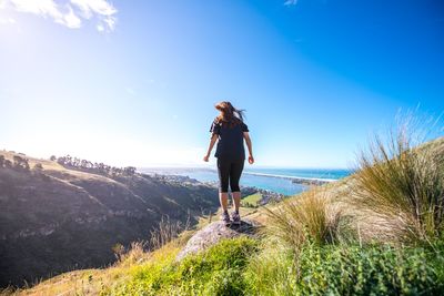 Full length of woman standing on mountain peak