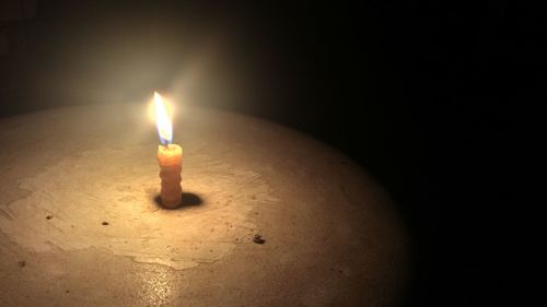 Close-up of illuminated candles in darkroom