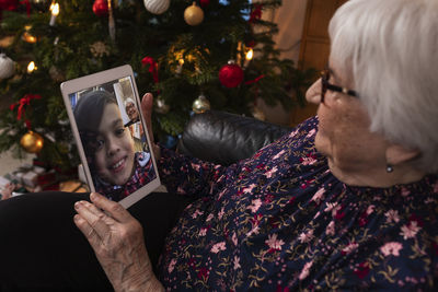 Senior woman having video call with granddaughter