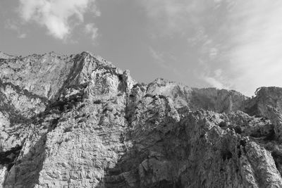 Low angle view of rocky mountains against sky