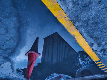 Reflection of building in puddle on road